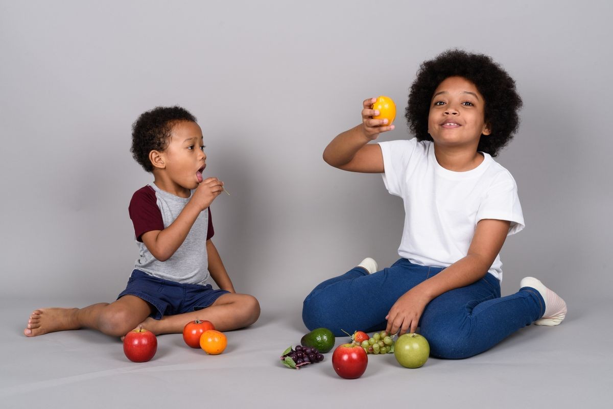 Studio shot of young cute African siblings together against gray background